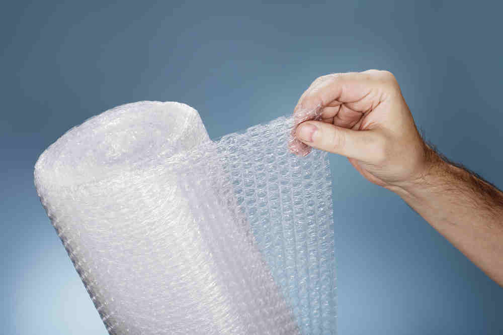hand holding a roll of bubble wrap
